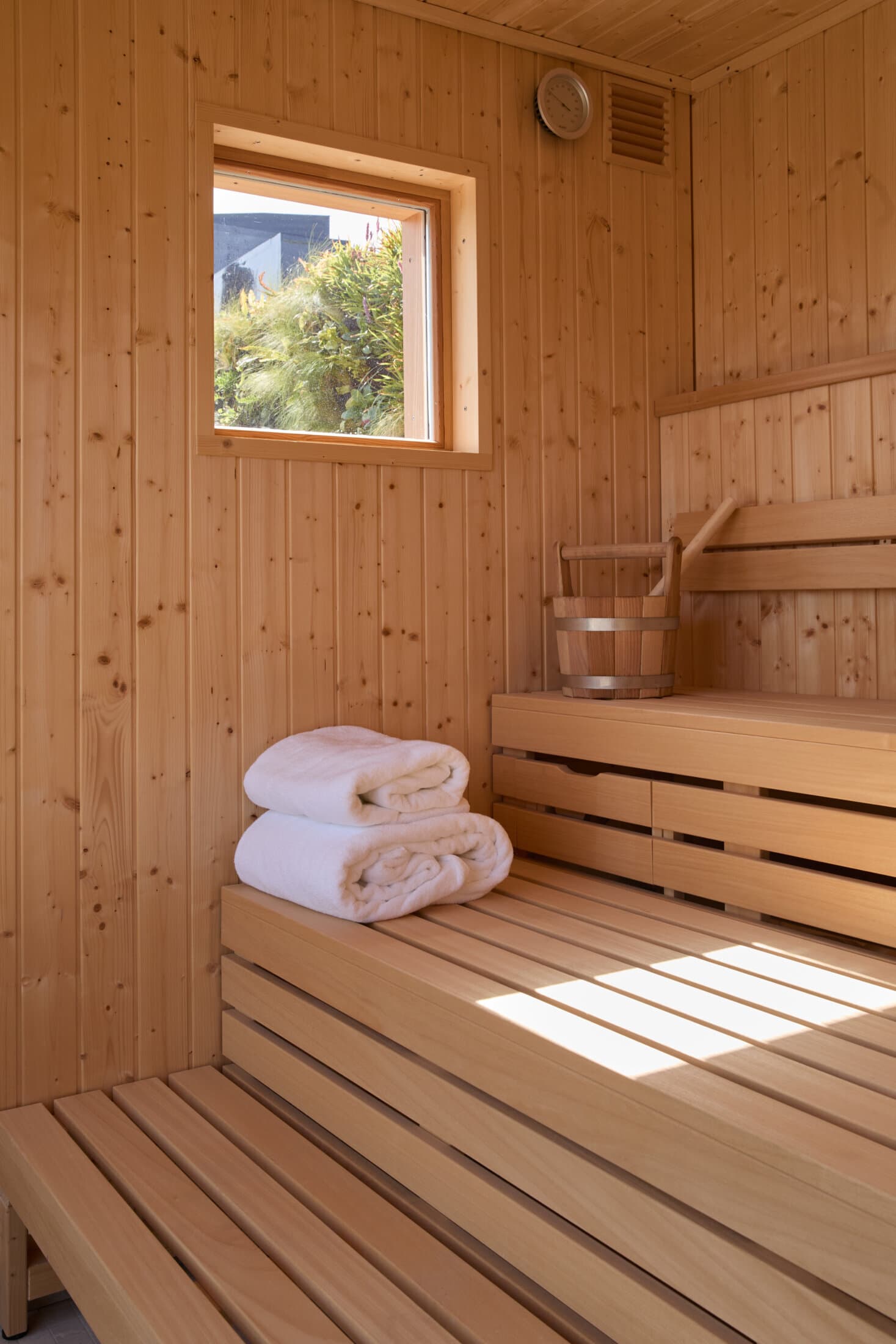 Wood-panelled sauna with warm bench lighting
