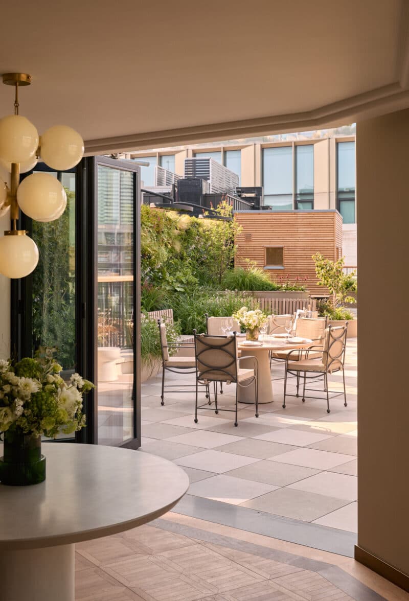 Penthouse balcony dining table at dusk with city views