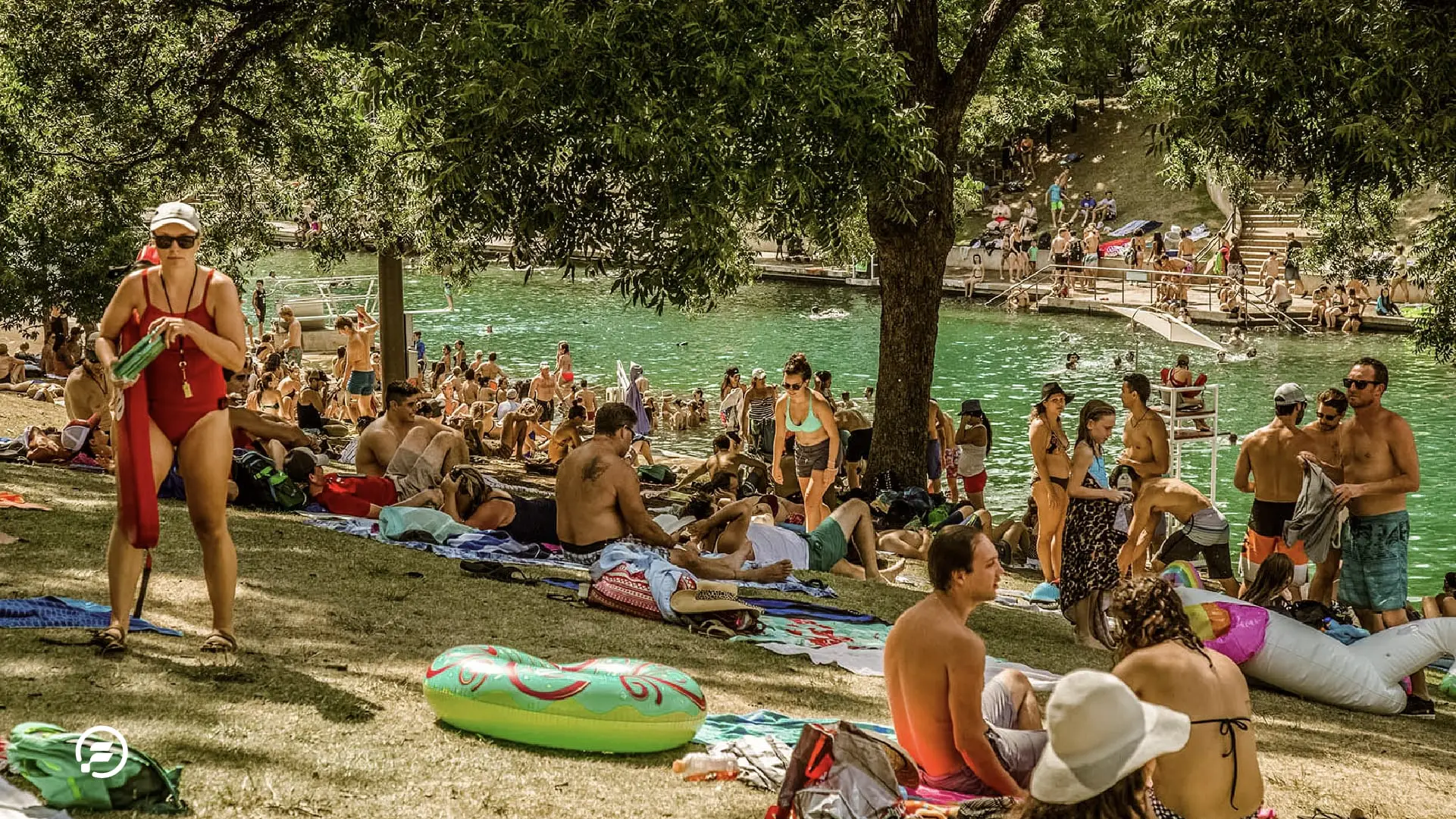 A crowd of people enjoying the sun and water at Barton Springs Pool.
