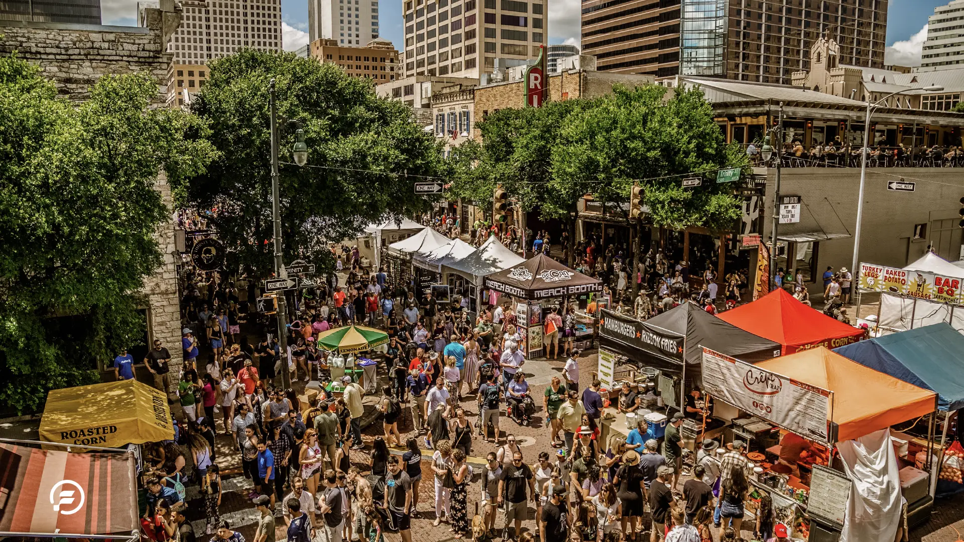 The Pecan Street Festival in full swing, with people walking between stands and enjoying the beautiful weather.