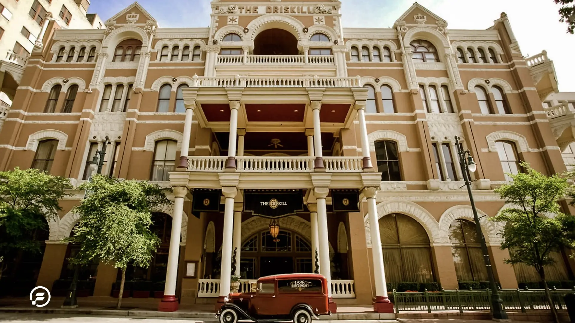 The exterior of the Driskell hotel with an antique car parked outside.