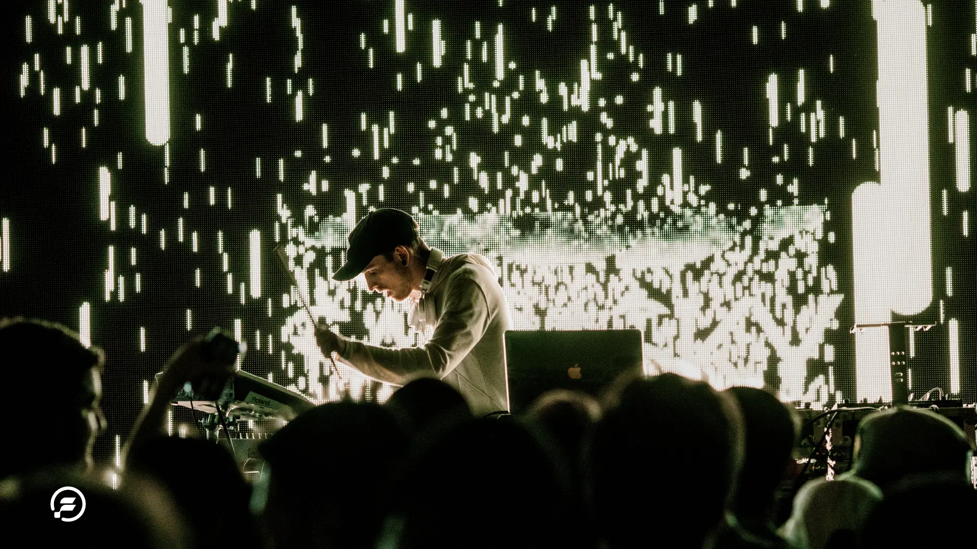 A musician playing his laptop on stage.