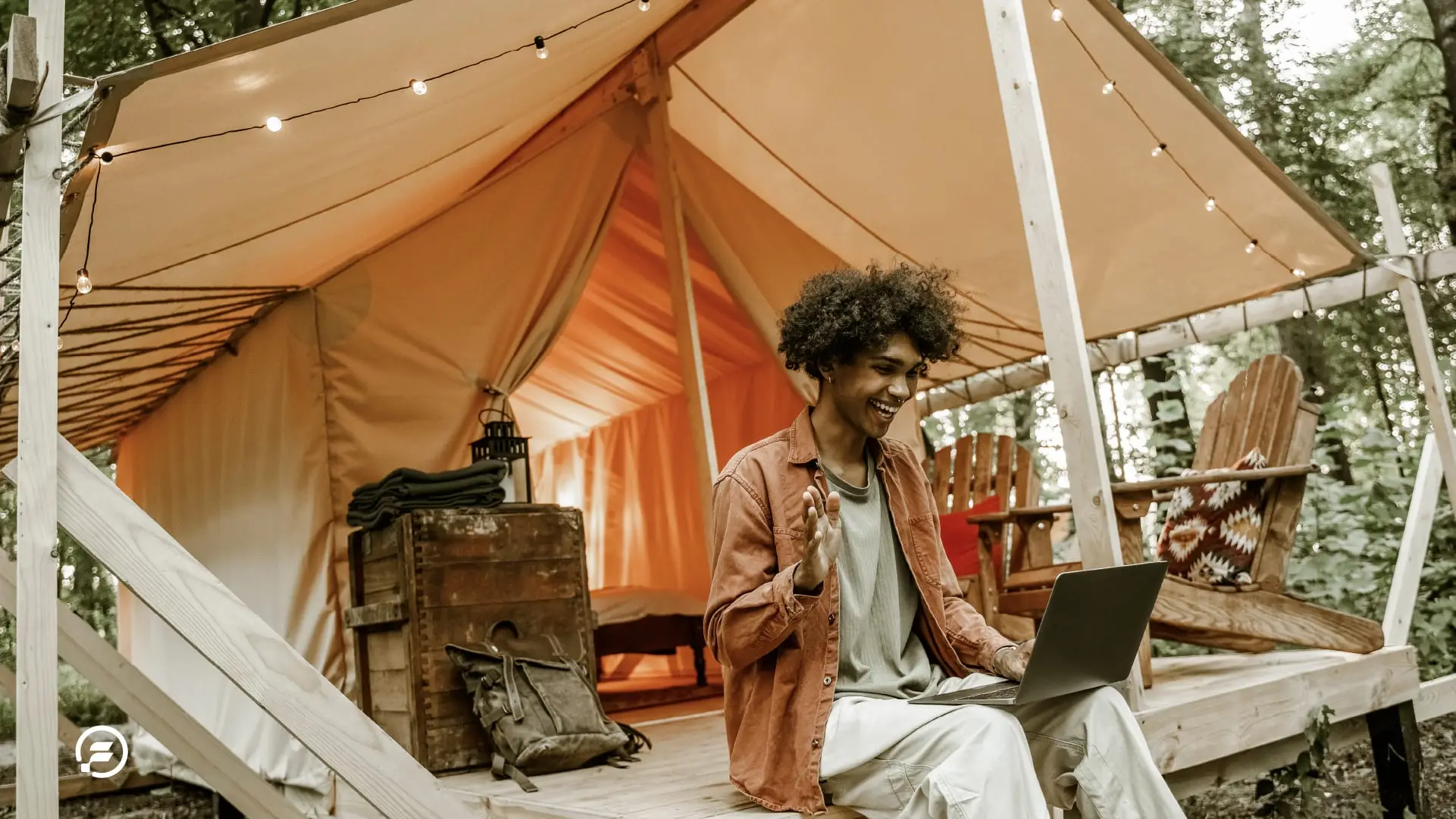 A digital nomad working outside at a campsite using a laptop